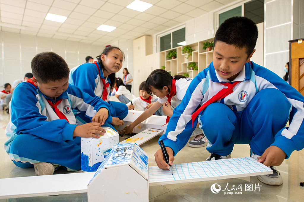 5月29日,在中国酒泉卫星发射中心东风小学,学生们正在自制拼装空间站模型,寓教于乐,学习航天知识。人民网记者 翁奇羽摄